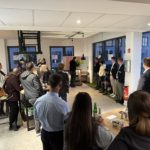 Frauen und Männer bei in einem Seminarraum. eine Person heftet Zettel an eine Tafel.