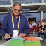 Unternehmensentwickler Michael Muench bei einer Veranstaltung an einem Tisch mit farbigen Blättern.